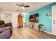 Comfortable living room with a large TV, wooden floors, and a teal accent wall creating a cozy atmosphere at 1165 S Fairplay Cir # B, Aurora, CO 80012