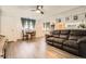 Inviting living room features wood flooring, large sofa, and a dining nook near a window, enhanced by natural light at 1165 S Fairplay Cir # B, Aurora, CO 80012