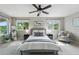 Comfortable bedroom featuring a ceiling fan, two windows, neutral walls, and an armchair at 3570 E Arapahoe Pl, Centennial, CO 80122
