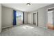 Carpeted bedroom with a window featuring blue curtains and closet at 3570 E Arapahoe Pl, Centennial, CO 80122
