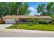 Charming ranch-style home featuring a lush front lawn and beautiful landscaping with mature trees and an American flag at 3570 E Arapahoe Pl, Centennial, CO 80122