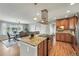 Bright kitchen featuring wooden cabinets, a granite countertop island, stainless steel appliances, and an adjacent dining area at 3570 E Arapahoe Pl, Centennial, CO 80122