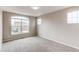 A bright bedroom is illuminated by a large window, showcasing neutral walls and carpet, offering a cozy atmosphere at 5597 S Buchanan St, Aurora, CO 80016