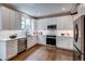 Modern kitchen with white cabinetry, stainless steel appliances, and hardwood floors at 5597 S Buchanan St, Aurora, CO 80016