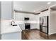 Modern kitchen with white cabinets, stainless steel appliances, and hardwood floors at 5597 S Buchanan St, Aurora, CO 80016