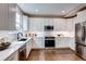 Kitchen with white cabinets, stainless steel appliances, and hardwood floors at 5597 S Buchanan St, Aurora, CO 80016