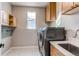 Laundry room featuring modern washer and dryer, ample storage cabinets, and stylish flooring at 5597 S Buchanan St, Aurora, CO 80016