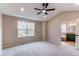 Bright main bedroom featuring a ceiling fan, large window, neutral walls, and ensuite bathroom at 5597 S Buchanan St, Aurora, CO 80016
