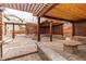 Outdoor patio area featuring pavers, covered structures, stone seat, and fire pit at 5597 S Buchanan St, Aurora, CO 80016
