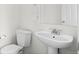 Bathroom with white fixtures, toilet, and pedestal sink at 701 N Roslyn St # 36, Denver, CO 80230