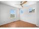 Bright bedroom with hardwood floors, ceiling fan, and three windows at 701 N Roslyn St # 36, Denver, CO 80230
