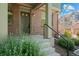 Inviting entrance with a dark colored front door, landscaping and brick accents at 701 N Roslyn St # 36, Denver, CO 80230