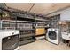 Functional basement laundry area with washer, dryer and storage shelving at 2606 W Alamo Ave, Littleton, CO 80120