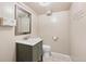 Charming basement bathroom featuring a modern vanity, toilet, and decorative mirror with vanity lighting at 2606 W Alamo Ave, Littleton, CO 80120