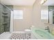 Well-lit bathroom features a mosaic tile floor and a shower with green tiling at 2606 W Alamo Ave, Littleton, CO 80120