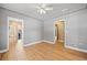 Well-lit bedroom featuring ceiling fan, hardwood floors, and doorways to other rooms at 2606 W Alamo Ave, Littleton, CO 80120