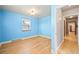 Blue bedroom with hardwood floors, natural light, and door to hall at 2606 W Alamo Ave, Littleton, CO 80120