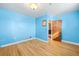 Bright blue bedroom featuring hardwood floors and a view to the kitchen at 2606 W Alamo Ave, Littleton, CO 80120