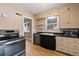 A charming kitchen with stainless steel appliances, wood cabinets, and a double basin sink under the window at 2606 W Alamo Ave, Littleton, CO 80120