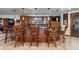 Basement wet bar with wooden cabinetry and seating at 9977 Elkhorn St, Littleton, CO 80127