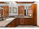 Bathroom with double sinks, wood cabinets, and a corner vanity at 9977 Elkhorn St, Littleton, CO 80127
