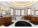 Spa-like bathroom featuring double vanities, a large soaking tub, and marble floors at 9977 Elkhorn St, Littleton, CO 80127