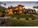Luxury home with stone accents, expansive lawn, and mountain views at dusk at 9977 Elkhorn St, Littleton, CO 80127