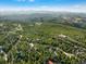 Breathtaking aerial view of a mountain home nestled among lush green trees with majestic mountain views in the distance at 44 Linn Ln, Golden, CO 80403