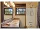 Bathroom featuring rustic wood trim, a sink with a tile countertop, and a shower-tub combination at 44 Linn Ln, Golden, CO 80403