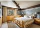 Comfortable bedroom with wood accent wall, rustic wood trim, and a queen-sized bed at 44 Linn Ln, Golden, CO 80403