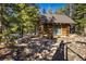 Charming log cabin nestled among trees with a small seating area at 44 Linn Ln, Golden, CO 80403