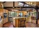 Spacious kitchen featuring wood cabinets, granite counters, stainless appliances, and an island with bar seating at 44 Linn Ln, Golden, CO 80403