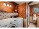 Laundry room with wallpaper, wood trim, a washer and dryer, and a walk-in shower at 44 Linn Ln, Golden, CO 80403