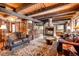Open-concept living room with wood beams, stone fireplace, and rustic furnishings at 44 Linn Ln, Golden, CO 80403