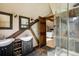 Bright bathroom features double sinks, stone tile floors, walk-in shower, and wood beam details at 44 Linn Ln, Golden, CO 80403