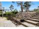 Backyard with stone steps and mature landscaping leading to a deck, perfect for enjoying the outdoors at 19640 Four Winds Way, Monument, CO 80132