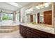 Bright bathroom with soaking tub, vanity with dual sinks and large mirror at 19640 Four Winds Way, Monument, CO 80132