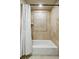 Bathroom features a white bathtub and light patterned tiles surrounded by a floral print curtain at 19640 Four Winds Way, Monument, CO 80132