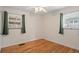 Empty bedroom with hardwood floors, a ceiling fan, and two windows at 3075 N Elm Ave, Denver, CO 80207