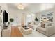 Bright living room featuring hardwood floors, a large window, and a neutral color palette, creating a welcoming atmosphere at 3075 N Elm Ave, Denver, CO 80207
