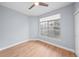 Bright bedroom with light blue walls, wood-look floors, and a window with white blinds at 9590 E Florida Ave # 1025, Denver, CO 80247