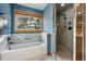 Bathroom features a soaking tub with tile surround and a separate glass-enclosed shower at 4468 S Zenobia St, Denver, CO 80236