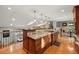 Open kitchen design with a granite island countertop, hardwood floors, and modern pendant lighting at 4468 S Zenobia St, Denver, CO 80236