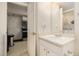 Bright bathroom featuring a single vanity, mirror and an open door showing a glimpse of the kitchen at 1655 S Buckley Cir, Aurora, CO 80017