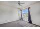 Bright bedroom with neutral carpet, ceiling fan, and a large window offering a view at 1655 S Buckley Cir, Aurora, CO 80017