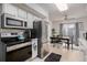 Well-equipped kitchen with stainless steel appliances, white cabinets, and an adjacent dining area at 1655 S Buckley Cir, Aurora, CO 80017