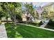 Street view of well-kept townhomes with vibrant colors, lush lawns, sidewalks, and tree-lined street at 1655 S Buckley Cir, Aurora, CO 80017