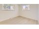This sunny bedroom features two windows and light wood flooring at 5780 W 5Th Ave, Lakewood, CO 80226
