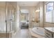 Bright bathroom with shower, soaking tub, and view into a bedroom at 10659 Montecito Dr, Lone Tree, CO 80124
