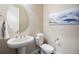 Half bathroom with a modern sink, oval mirror, and elegant artwork at 10659 Montecito Dr, Lone Tree, CO 80124